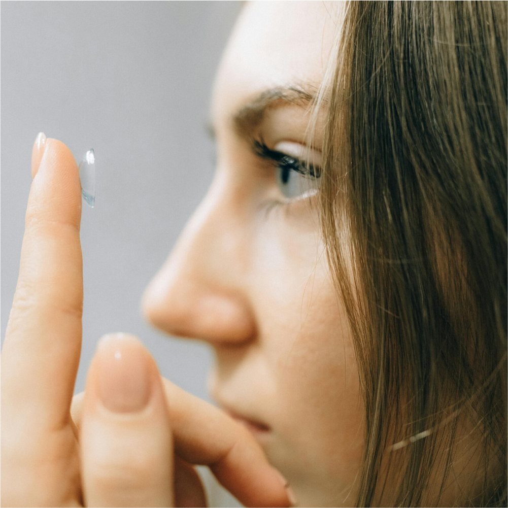 Mujer sosteniendo una lente de contacto en su dedo lista para su adaptación.